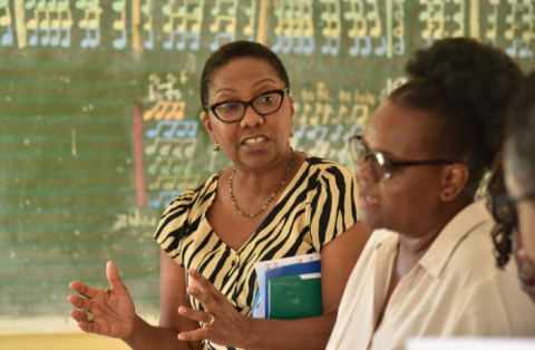 Alicia Herbert (FCDO) and Loyce Nhandara (SAGE) pictured in a classroom on a recent visit. A blackboard covered in musical notes is in the background.