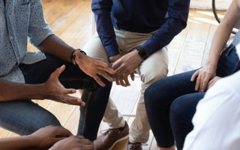 A group of four people sitting and talking together.