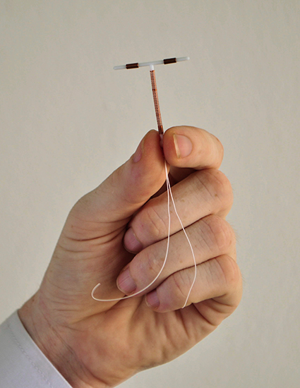 Male hand holding IUD