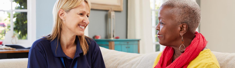 Social worker smiling at a client on a sofa
