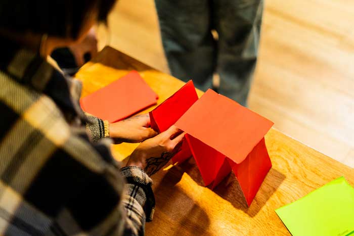 a close up of the hands of a young person engaged in a crafts workshop