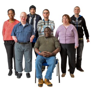 A group of people stood together with one seated