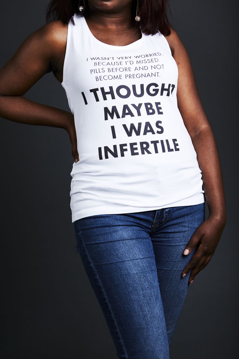 A view of a woman's torso (from chin to hip height) wears a sleeveless white top with the words 'I thought maybe I was infertile'.