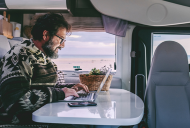 Man looking at a laptop while travelling somewhere