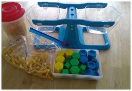 Photo of a a blue measuring tool, a tub of cereal and bags of pasta on a table