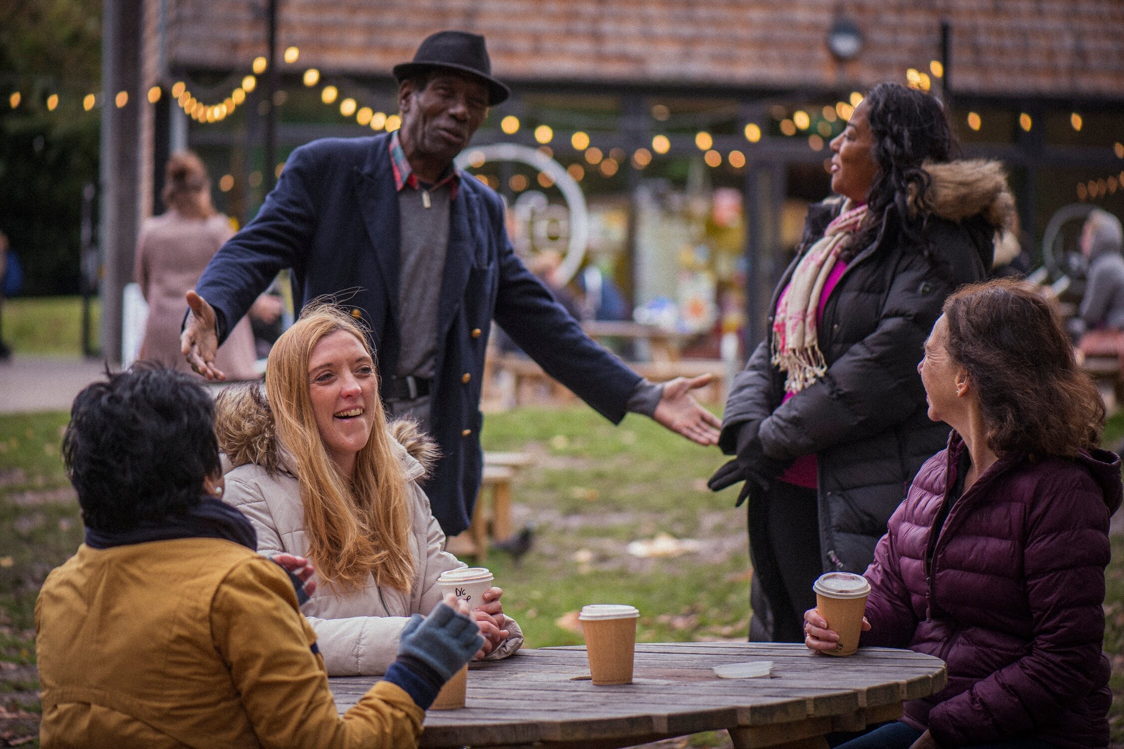 A group of people sat together outside in a festival