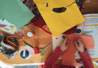 Child cutting out shapes from coloured paper