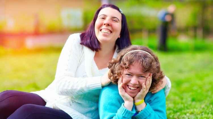 image of a two smiling girls on a lawn