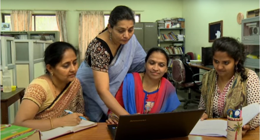 Four Indian women studing and looking at laptop computer