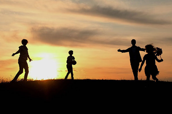 Silhouette style picture that shows 4 people playing something.