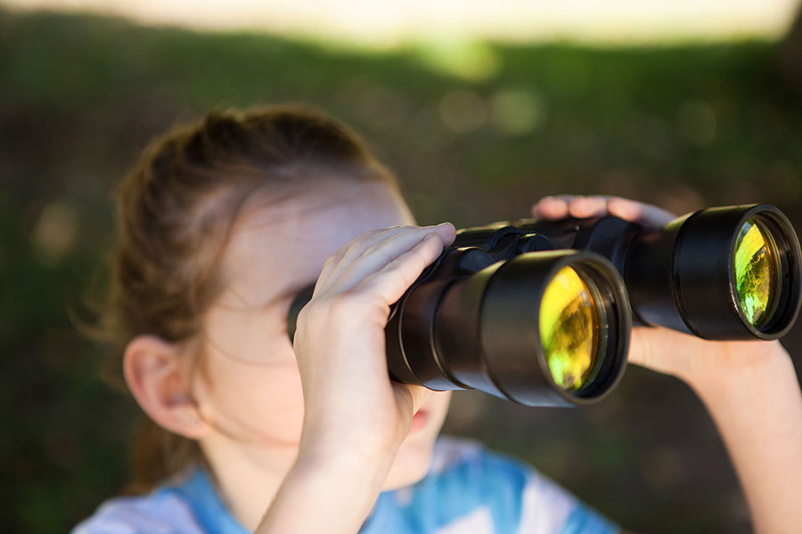 A girl looking through binoculars.