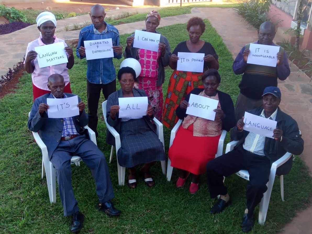 a group of people standing and sitting, holding signs that read "Language matters", "Diabetes depression", "I can make it", "it is possible", "it is manageable", "It's all about language"