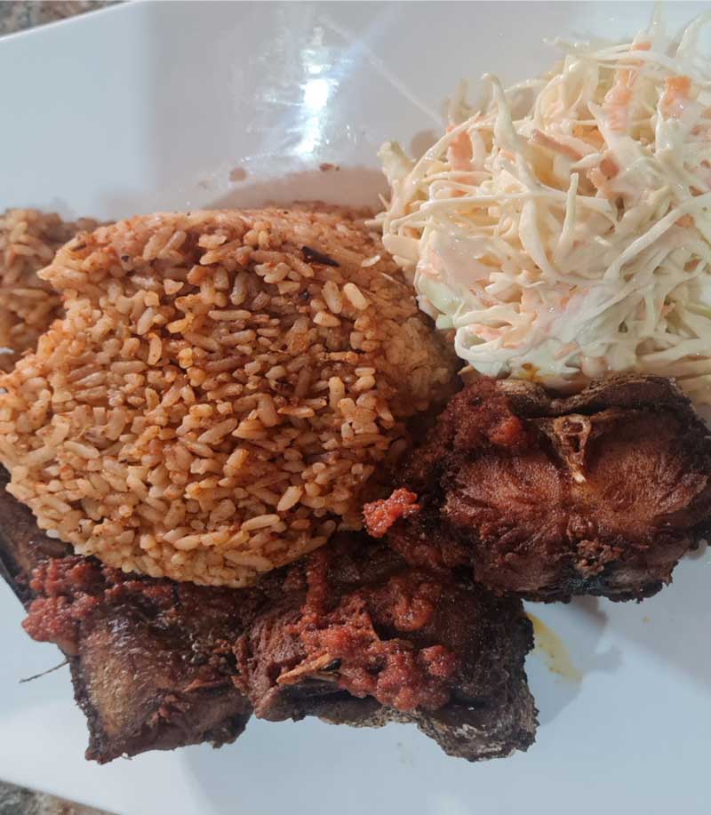 a photo of a portion of Jollof rice and chicken 