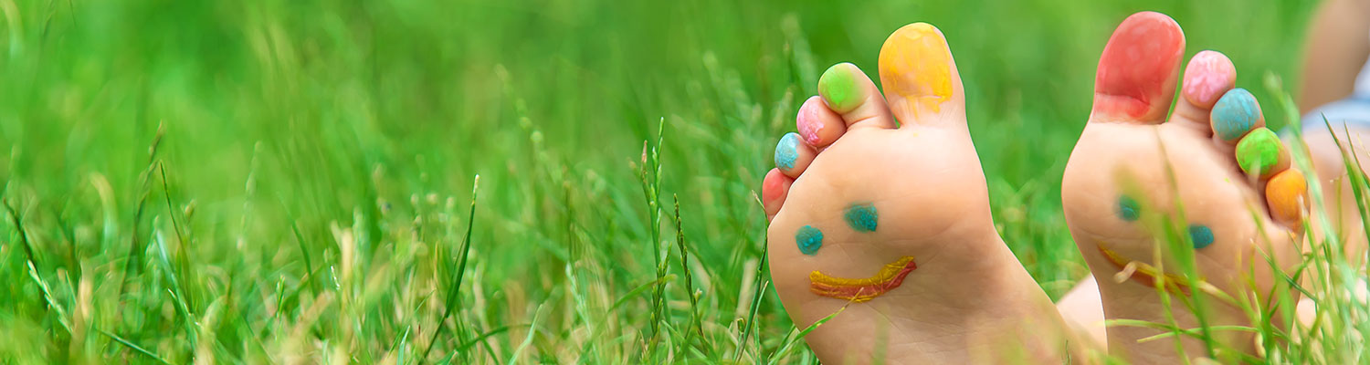 a pair of child's feet with smiley faces painted on