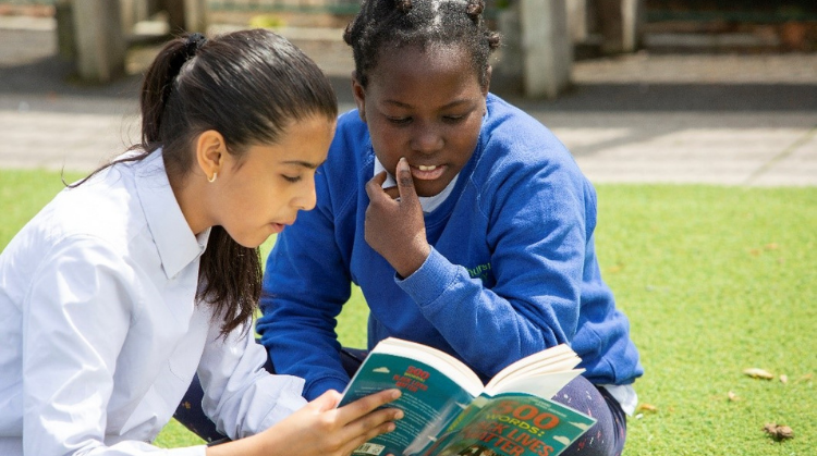 Image shows two kids reading a book