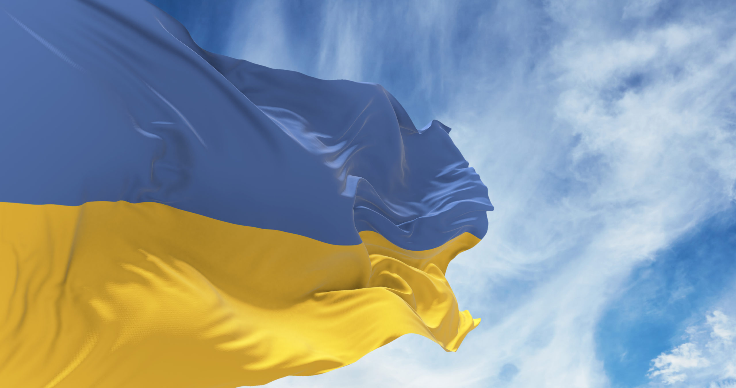 Ukrainian flag blowing in the wind against blue sky