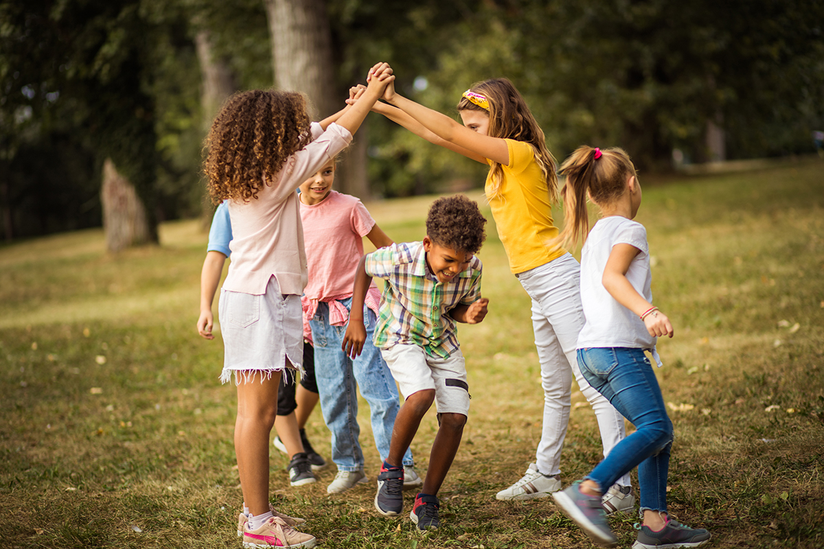 A group of children playing in a field outside