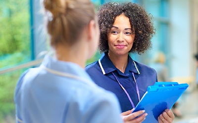 Nurses talking and holding clipboard