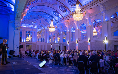 Guests sat in a large room around large round tables at the Research Excellence Awards held in London