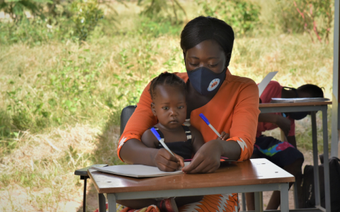 The picture is of a young child and their mother studying in a classroom