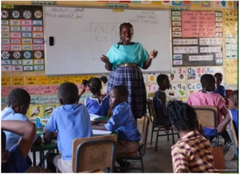 a teacher talking to her students during a lesson in a primary school in Africa