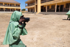 Girl holding a camera and taking a picture