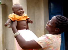 an African young mother holding her smiling baby