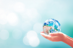 human hands holding globe on a blurred blue background