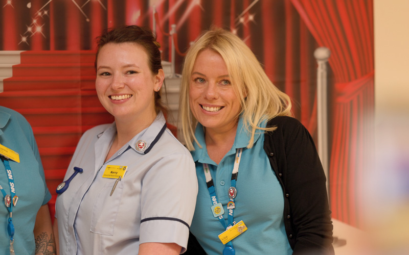 Two NHS employees smiling.