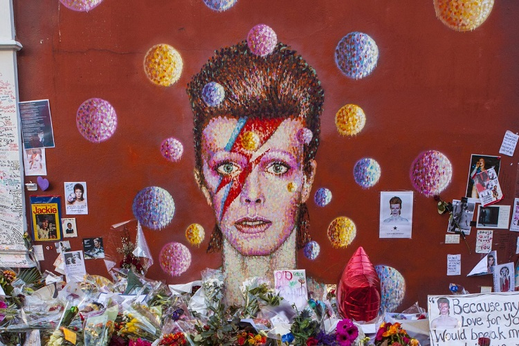 A photograph of David Bowie's 'Ziggy Stardust' painted on a brick wall