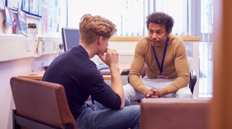Young person talking to a counsellor in a university office.